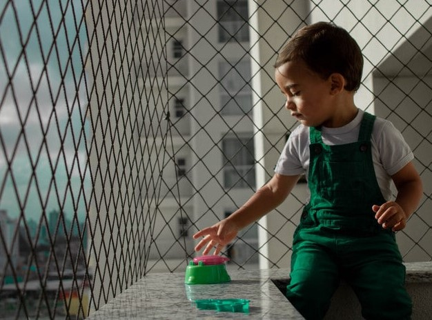 Criança brincando perto da rede de proteção